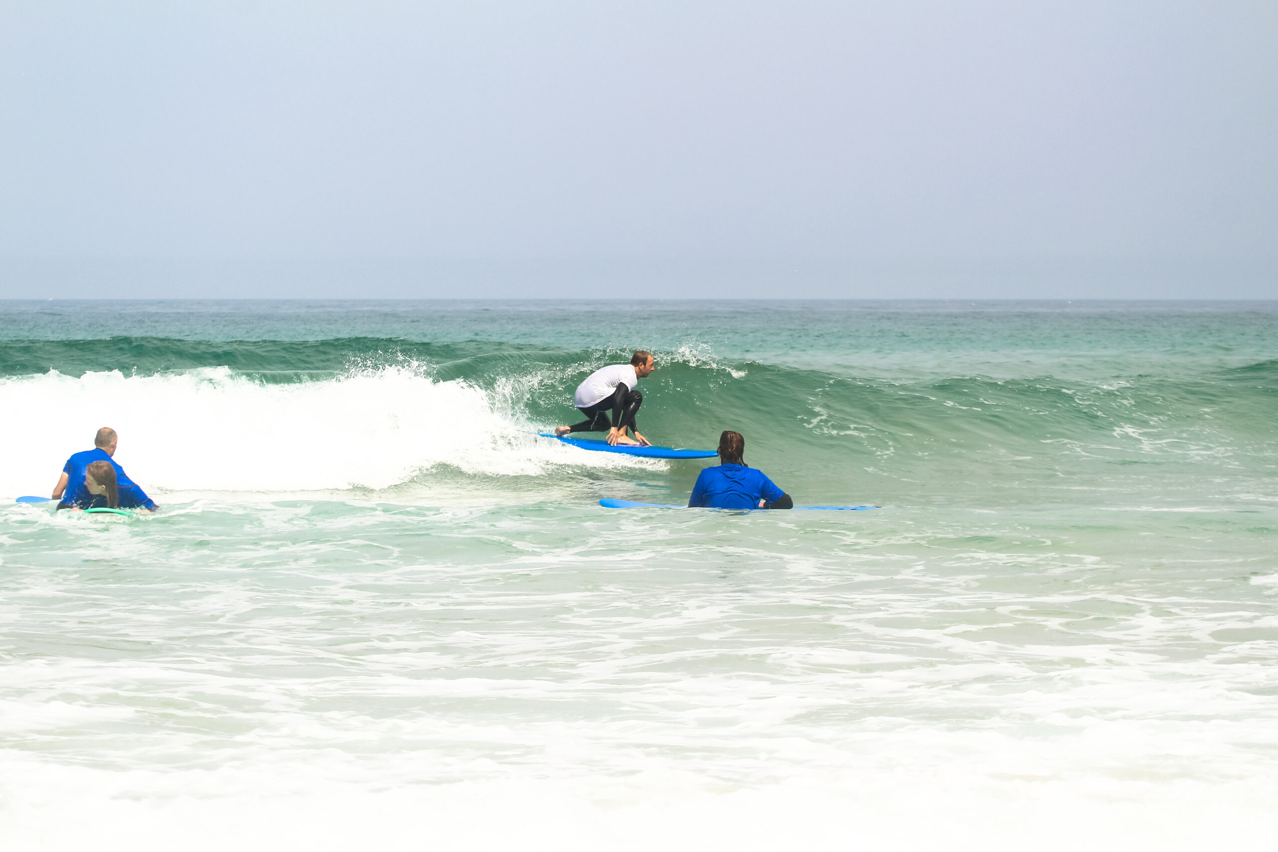 Surf Instructor Pedro giving an advanced surf lesson, riding a wave while demonstrating the correct posture and stance on the board.