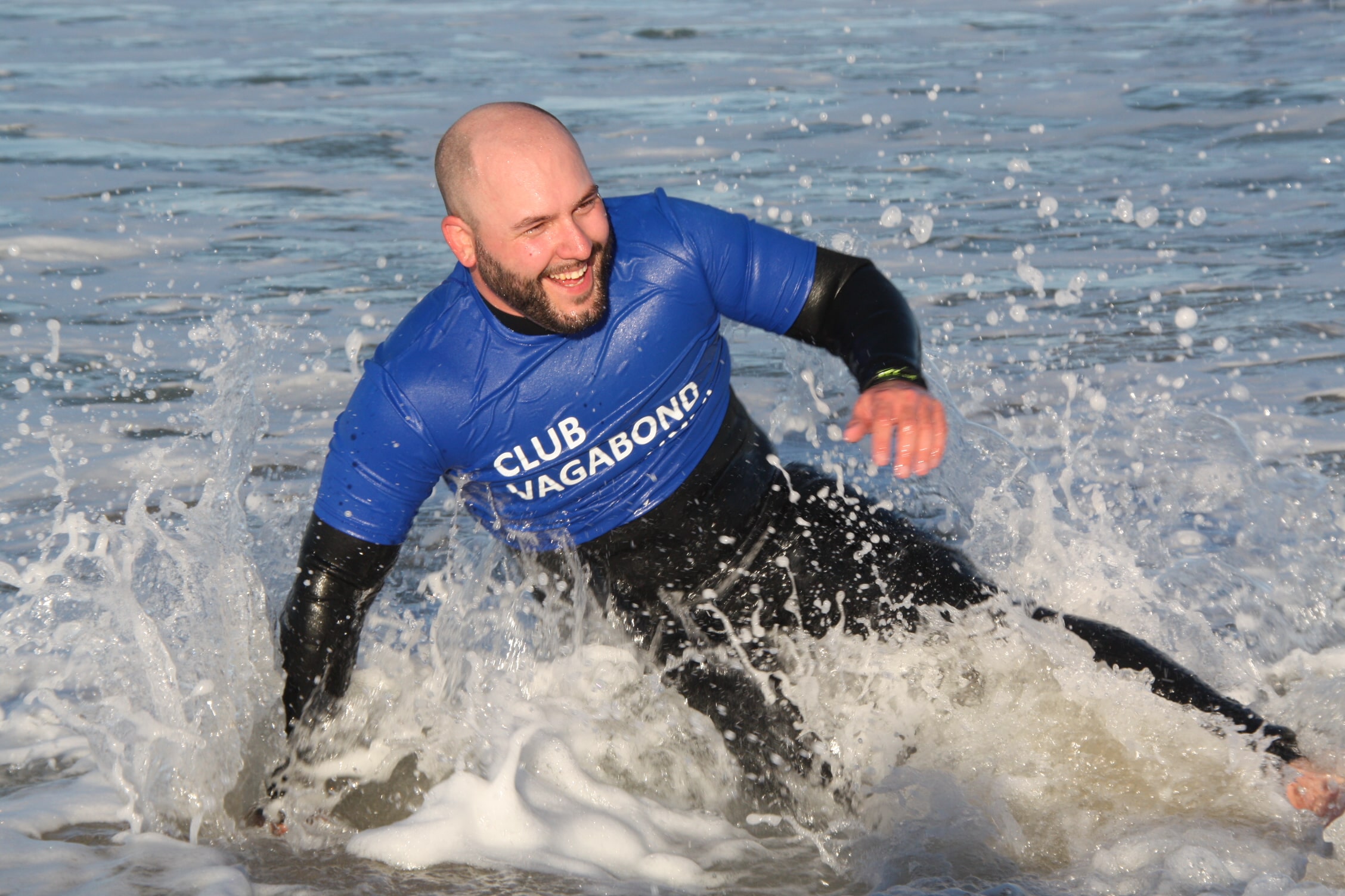 Club Vagabond Surf Student finishing the ride on a small phase, smiling.